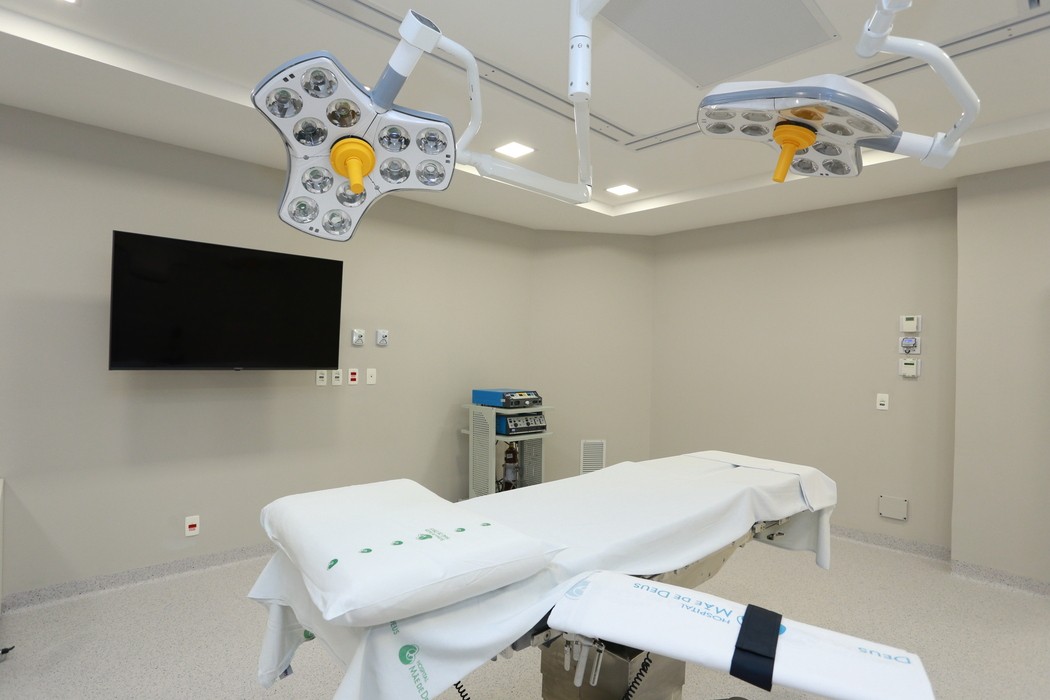 Sala cirúrgica hospitalar equipada com mesa operatória, iluminação cirúrgica e monitor médico em ambiente estéril, ilustrando artigo sobre cirurgia do aparelho digestivo