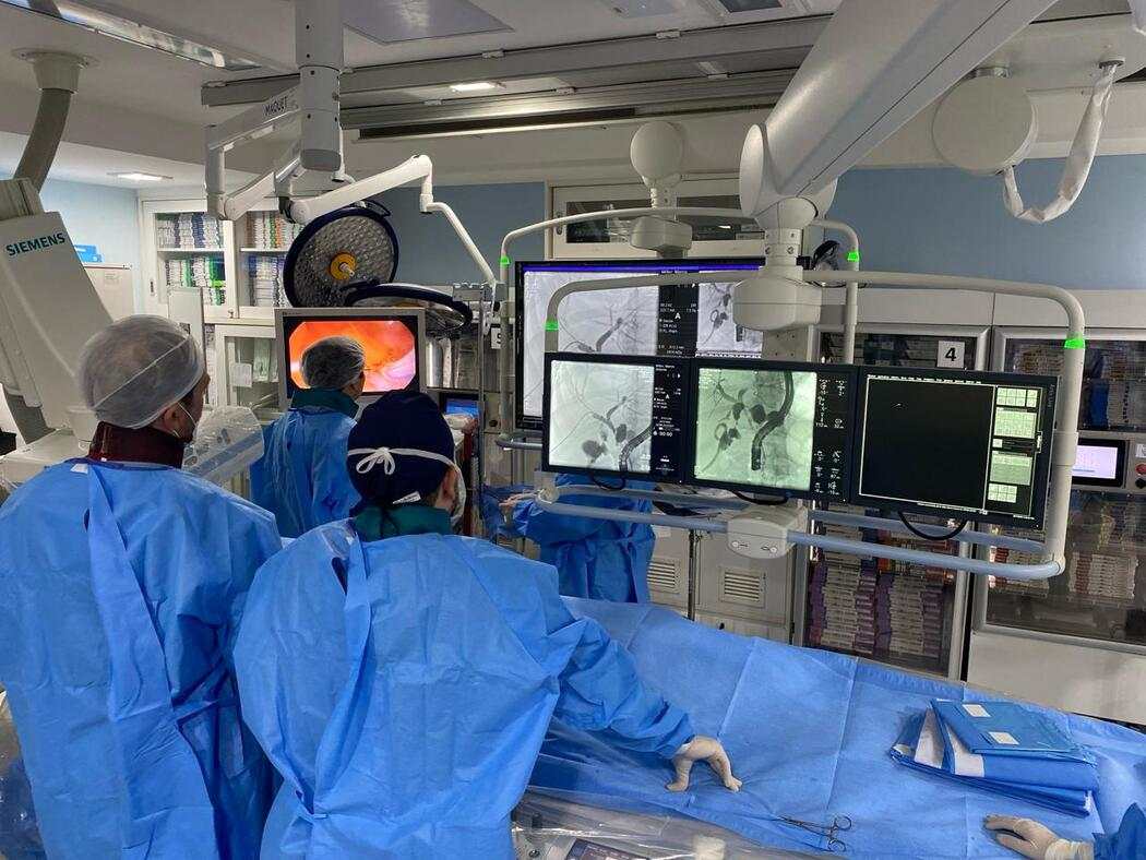Equipe médica em sala de radiologia intervencionista utiliza equipamentos de imagem e acompanha procedimentos por monitores, ilustrando artigo sobre radiologia intervencionista tratamentos