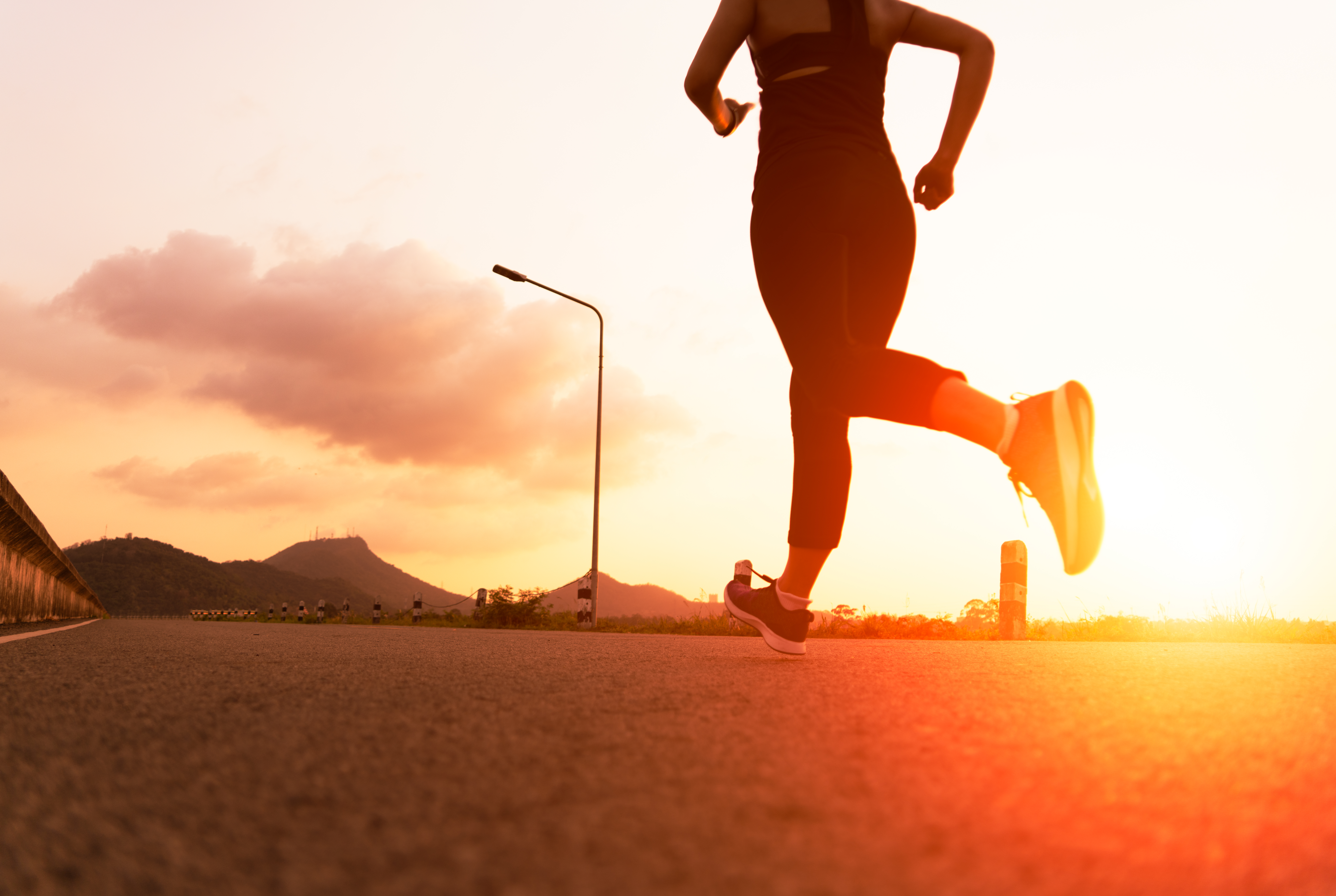 sport woman running on a road. Fitness woman training at sunset sport woman running on a road. Fitness woman training at sunset